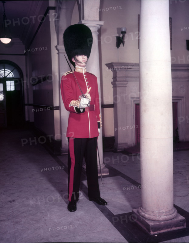Guards officer in full dress uniform with bearskin on and sword drawn, London,  Creator: Arthur Charles Kirby Ware.
