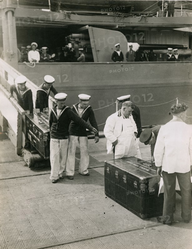 Bringing ashore the steel lined cases from the decks of H.M.S. Hood, July 1935. Creator: Topical Press Agency.