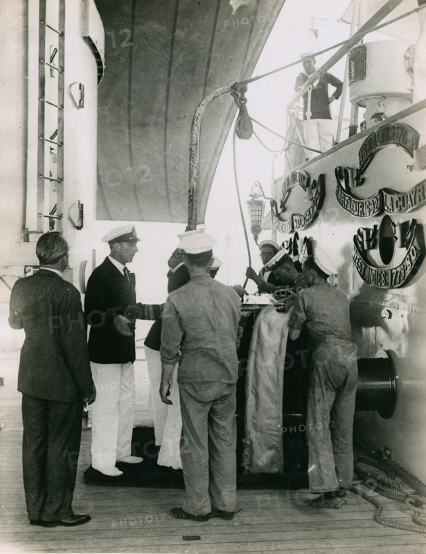 Preparing to hoist a case from the deck of  H.M.S. Suffolk at Portsmouth, July 1935. Creator: Topical Press Agency.