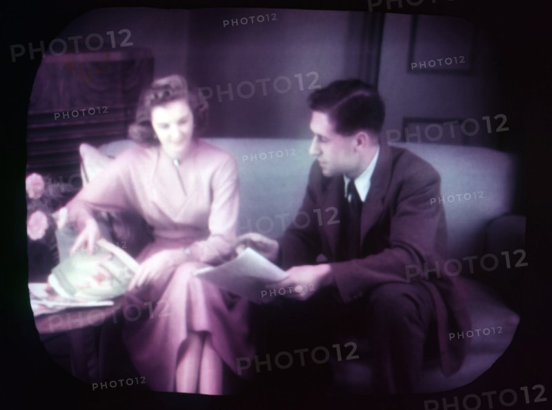 Couple sitting on sofa within TV screen, c1955. Creator: Arthur Charles Kirby Ware.