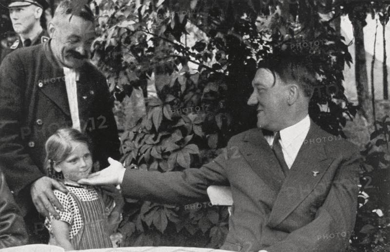 Hitler en villégiature à Obersalzberg, est salué par une famille de la région, vers1935