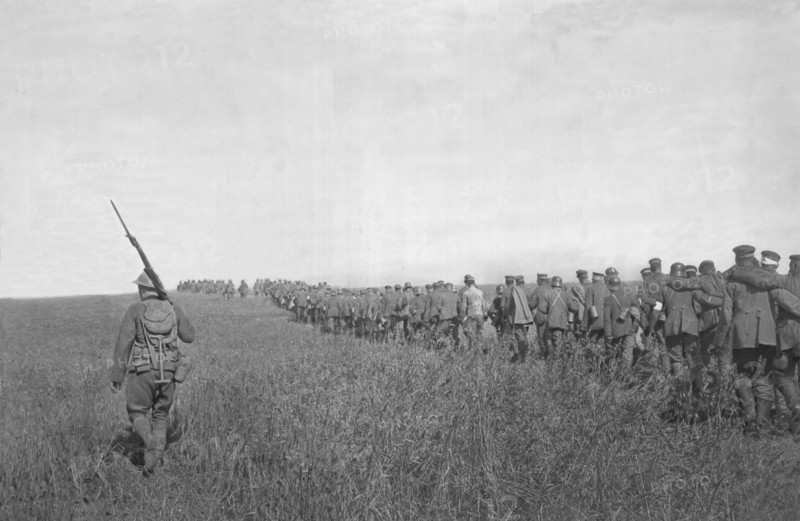 Colonne de prisonniers allemands emmenés vers l'arrière sous la garde d'un soldat américain. - Après la contre offensive franco-américaine du 18 juillet 1918, entre l'Aisne et la Marne.