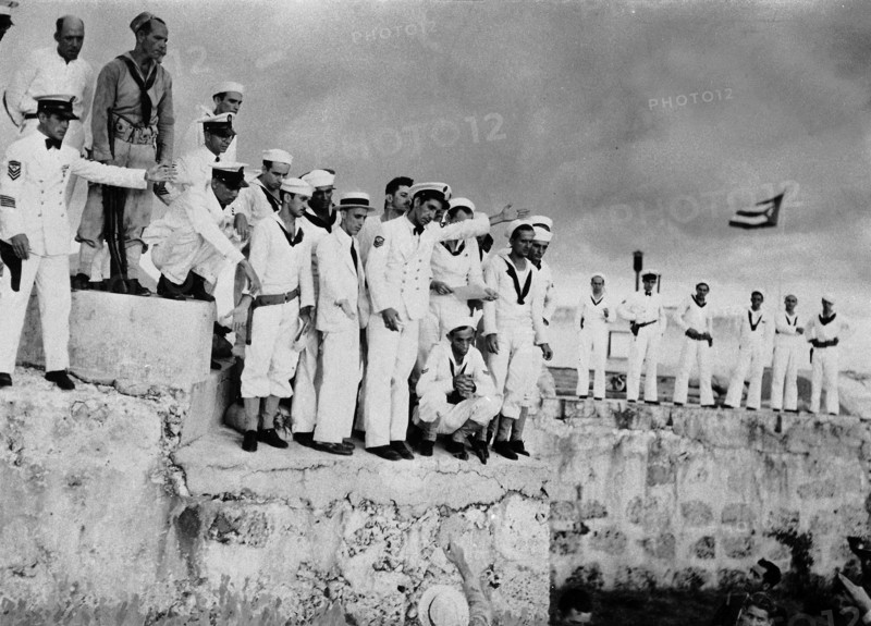 Le 8 septembre 1933, dans le port de La Havane à Cuba, les soldats de la marine cubaine se sont regroupés derrière le sergent SANTANA qui, le bras levé, harangue la foule pour s'opposer à l'arrivée du croiseur américain INDIANAPOLIS.  Alors que le secrétaire d'Etat de la marine américaine SWANSON se préparait à descendre à terre pour rencontrer l'ambassadeur Sumner WELLES, les marins, rejoints par les étudiants en armes menacent de tirer sur les Américains s'ils veulent débarquer. Devant cette hostilité, le croiseur poursuivra sa route vers le canal de Panama.