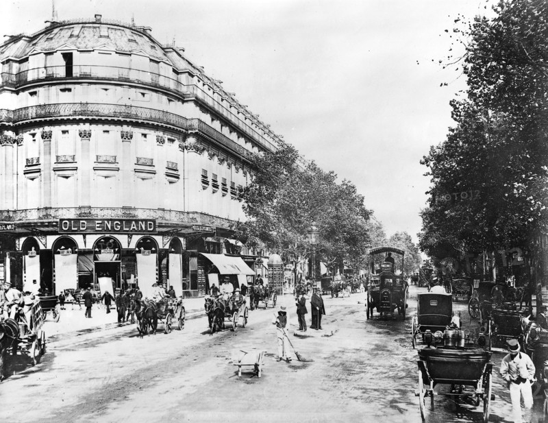 La circulation sur un grand boulevard parisien vers la fin du XIX siècle. Le passage des piétons, des voitures attelées, des fiacres, des calèches, des omnibus, des autobus attelés, devant le grand magasin Old England à Paris.