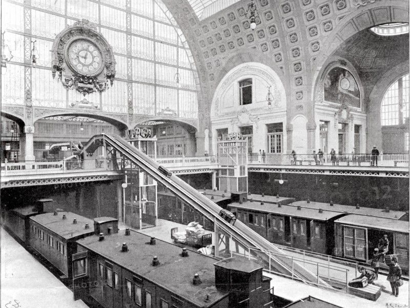 En septembre 1900, l'acheminement des bagages à l'arrivée d'un train à la gare d'Orléans, quai d'Orsay à Paris.  "A l'arrivée, les bagages déchargés des fourgons sont très rapidement montés sur les tables de distribution, dans la salle prcédant le vestibule de sortie, grâce à un ingénieux système de tapis roulant et de monte-charges."  Photographie et extrait d'article de L'Illustration du 15 septembre 1900.