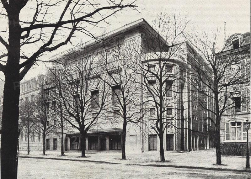 Façade du futur Théâtre des Champs-Elysées, d'après, Paris, 1912. L'immeuble (...) - dont nous avons pu facilement, grâce à une maquette très poussée, déterminer par anticipation, l'aspect définitif  d'ensemble - est construit en béton arméet sera revêtu de marbre blanc. la façade, déjà silhouttée, aura une hauteur totale de 24 mètres. le style, en sa sobriété ornementale, est pur et simpls. c'est de l'architecture grecque qui serait venue prendre  les conseils du goût français. les architectes, MM. Bouvard et Perret frères, ont cherché à réaliser la grandeur, le calme, la simplicité hiératique qui doivent présider à un temple de l'art, tout en tenant compte des soucis de confortable raffiné qui appartiennent à la construction moderne. (...) Une frise en marbre sculptée par M. Emile-Antoine Bourdelle représentera Apollon et les Muses (...) intérieurement, une grande fresque du peintre Maurice Denis (l'histoire de la Musique en quatre tableaux) décorera la salle." Illustration et extrai...