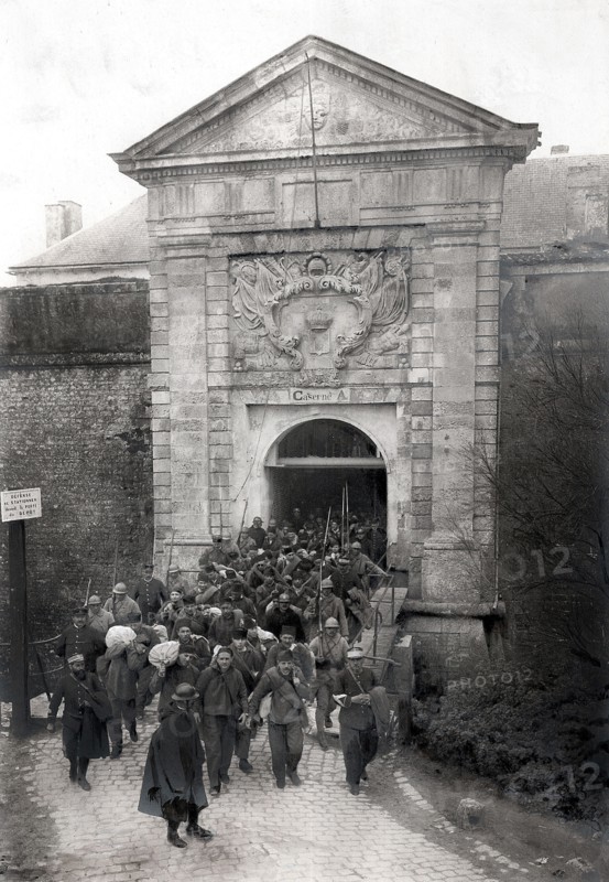 Police et justice en France au XX siècle. Les prisons, les bagnes. A Saint Martin de Ré, embarquement de forçats pour les bagnes en Guyane, mars 1926. Ayant en tête trois condamnés dangereux enchainés ensemble par les poignets, la longue colonne, que des soldats encadrent, baïonnette au canon, quitte la vieille citadelle.