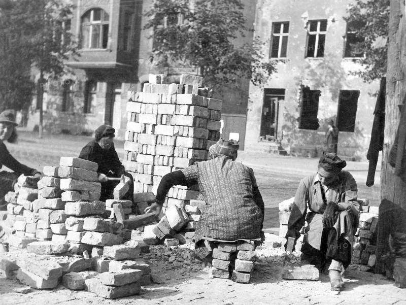 Dans la ville ravagée par les bombardements, la population de Berlin pour reconstruire leur ville, se livre au grattage des briques de récupération.