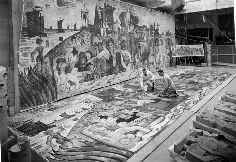 Préparation de l'Exposition internationale de 1937 (Paris) à la Manufacture nationale de Sèvres. Montage du panneau en grès de 12 mètres de long sur 4 mètres de haut destiné à la façade du pavillon de la Manufacture. Au fond, sur un chevalet, la composition originale en couleur de l'artiste M. Gromaire  dressée le long du mur, la reproduction en noir et en vraie grandeur de cette composition. Sur le sol, le panneau décoratif en voie d'assemblage.  Photographie parue dans L'Illustration du 24 avril 1937.