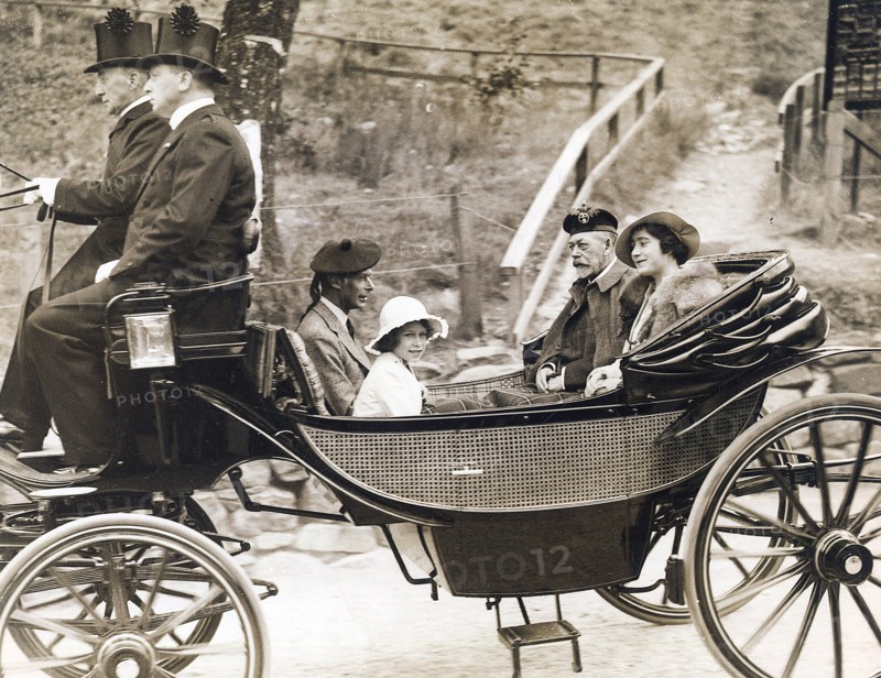 Se rendant à l'église de Crathie (Ecosse) en calèche, le roi George V, son fils le duc d'York, futur roi d'Angleterre George VI, qui succèdera à son frère Edouard VIII après l'abdication de ce dernier. A leur côté la duchesse d'York, née Elizabeth Bowes-Lyon et la princesse Elizabeth, future reine d'Angleterre Elizabeth II.  Photographie parue dans L'Illustration du 19 décembre 1936.