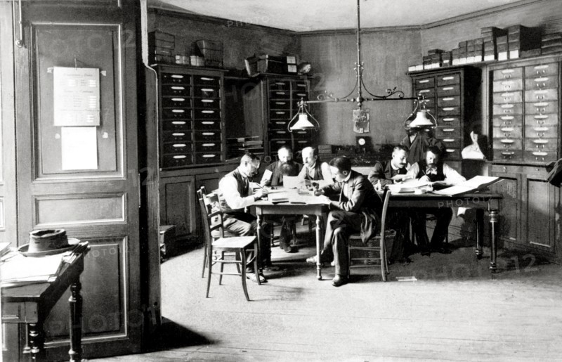 Les syndicats ouvriers en France en 1893.  Les membres de la permanence du syndicat des chemins de fer au travail. Le syndicat des chemins de fer représente alors le plus gros adhérent de la Bourse du Travail et possède la permanence la plus importante. Ses attributions: tenue de livres, comptabilité et caisse, rédaction des procès-verbaux, réception et classement des plaintes qui seront examinées, étude préparatoire des futures revendications... "C'est là, vraiment, une puissance: un simple mot d'ordre parti de cette permanence, un télégramme, et voilà demain tout le réseau de fer en grève, et il s'y mettra passivement, sans même demander pourquoi, comme viennent de le faire les cochers, comme tant d'autres tous les jours."  L'Illustration du 8 juillet 1893.