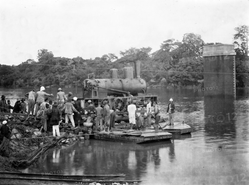 Dans les années 1910, pendant la construction de la ligne de chemin de fer franco-éthiopienne, transport d'une locomotive train sur l'eau avant l'achèvement de la construction d'un pont.  Photographie inédite de L'Illustration.
