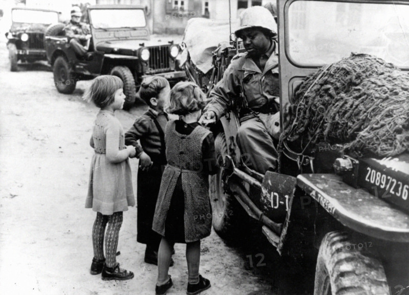 Un G.I. donne du chocolat à des enfants