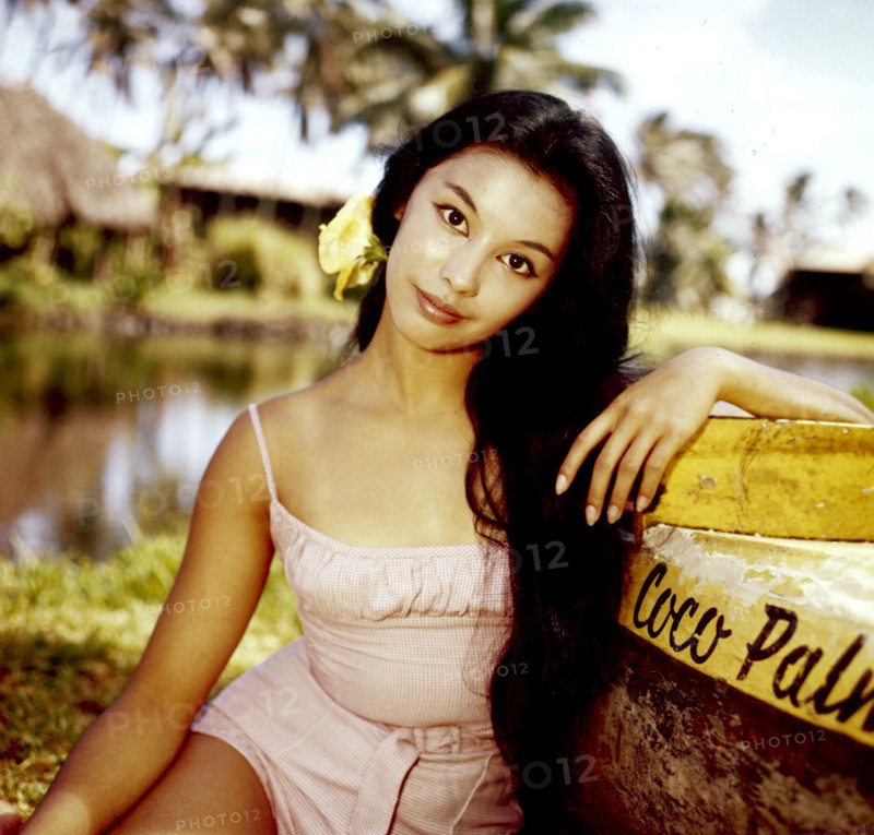 France NUYEN leaning against a boat