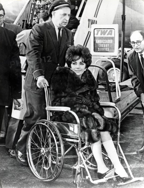 Elizabeth TAYLOR in a wheelchair, 1961