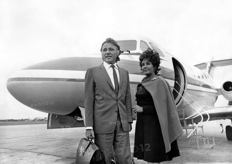 Elizabeth TAYLOR with Richard BURTON in front of plane, 1967