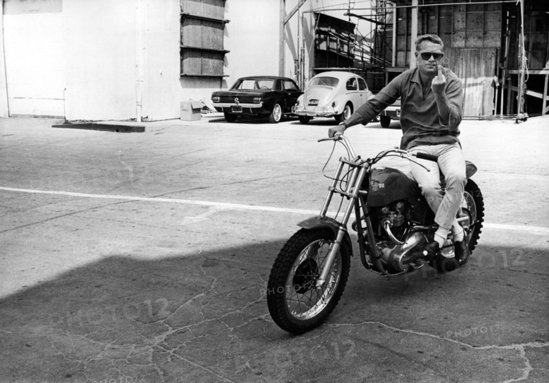 Steve McQUEEN sitting on motorcycle
