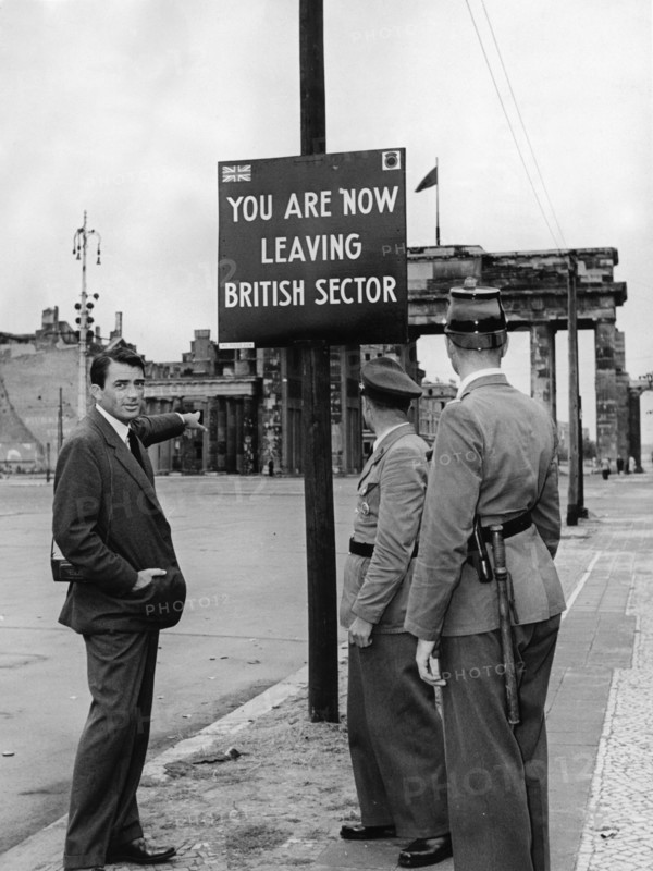 Gregory Peck with two border police officers in front of the Brandenburg Gate, 1958