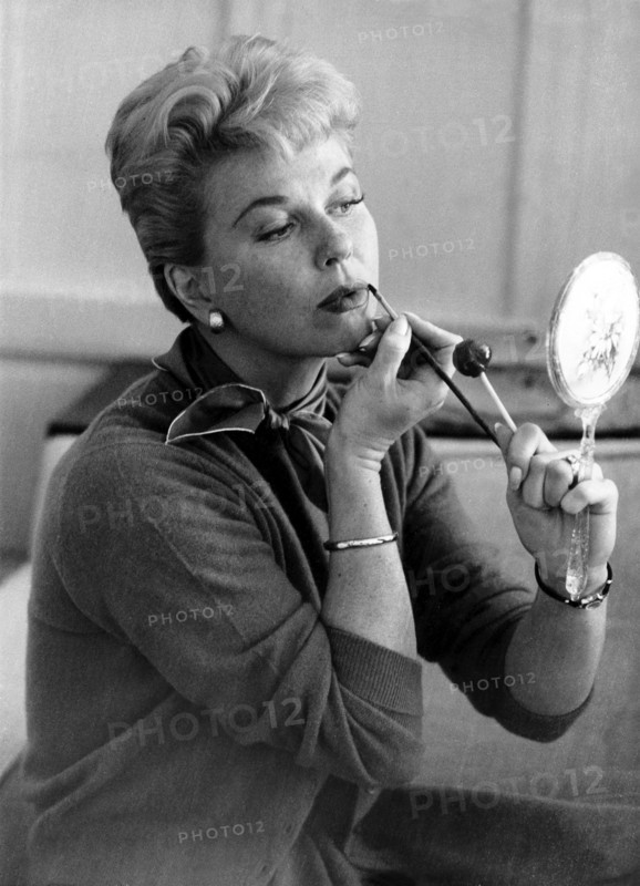 Doris DAY puts on her make-up using a make-up mirror
