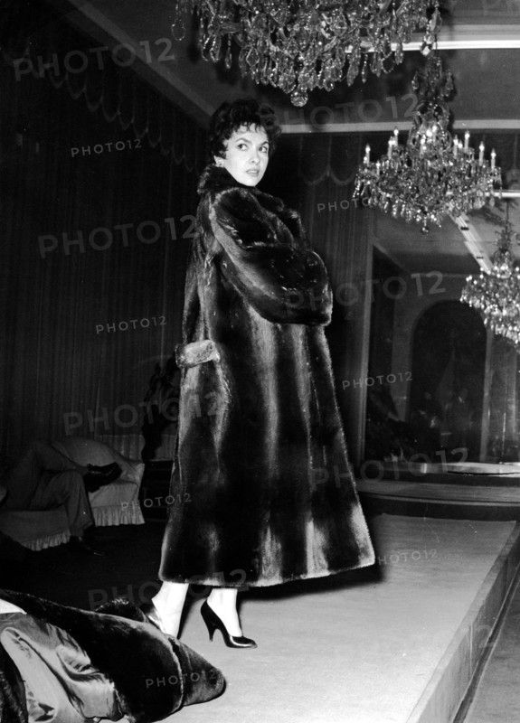 Gina LOLLOBRIGIDA trying on a fur coat, 1956