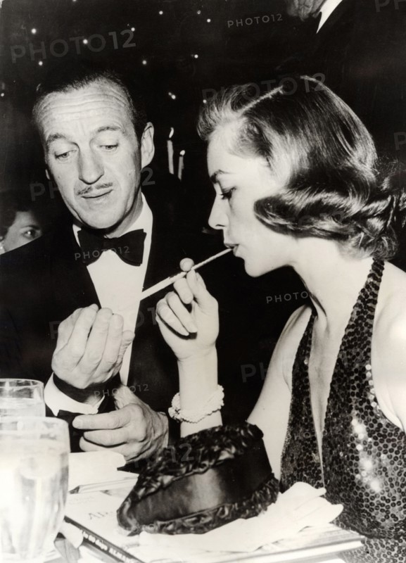 David NIVEN and Lauren BACALL at a party