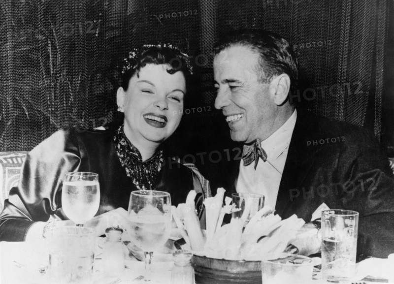 Judy GARLAND and Humphrey BOGART laughing at the dinner table, 1946