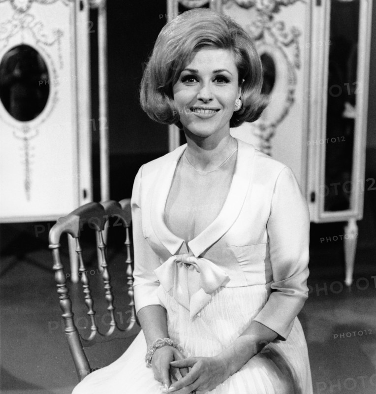 Bibi JOHNS sitting on a chair