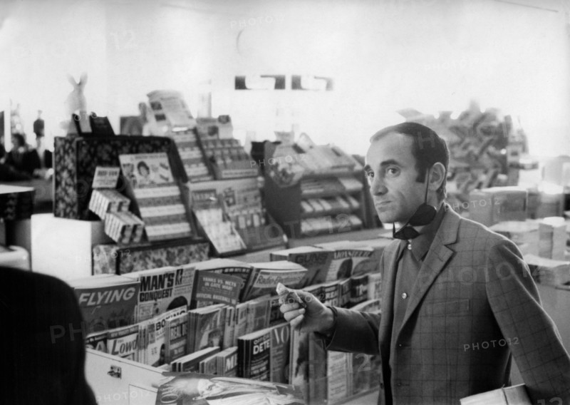Charles AZNAVOUR buys newspapers, ca. 1960