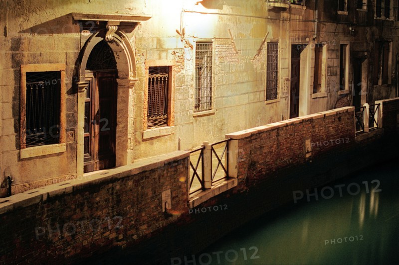 Illuminated alley along the canal, Venice