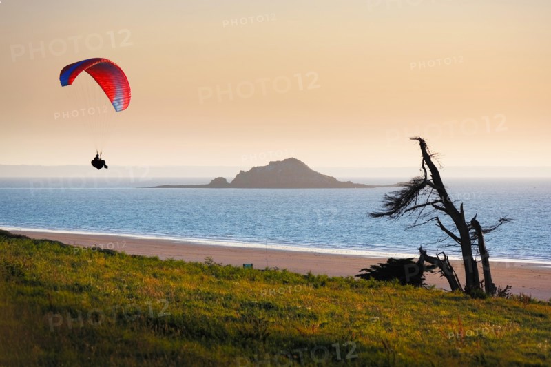 Solitary paraglider during sunset at shore side