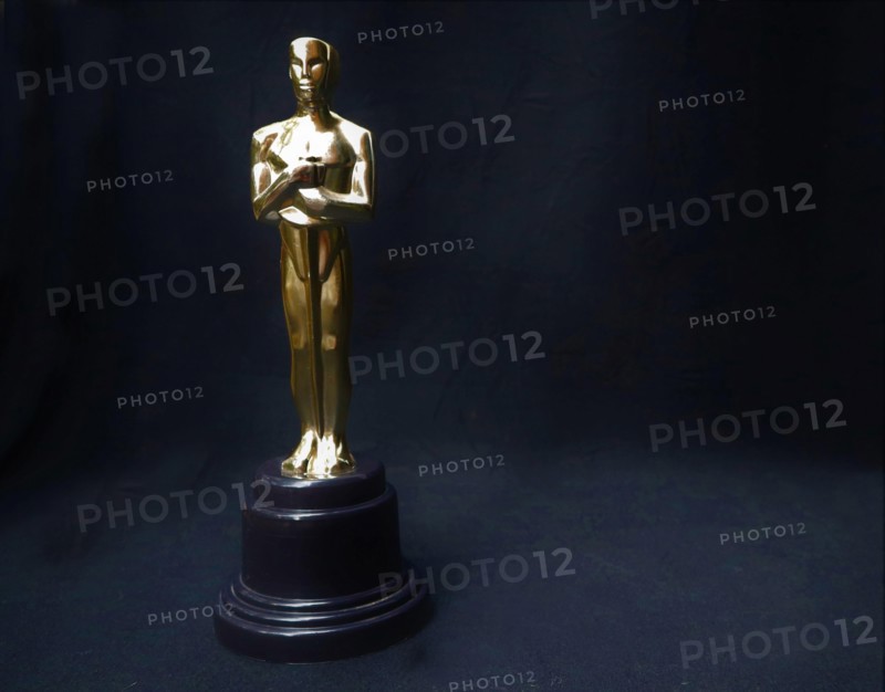 The golden statue of Oscar on a black background. Success and victory concept