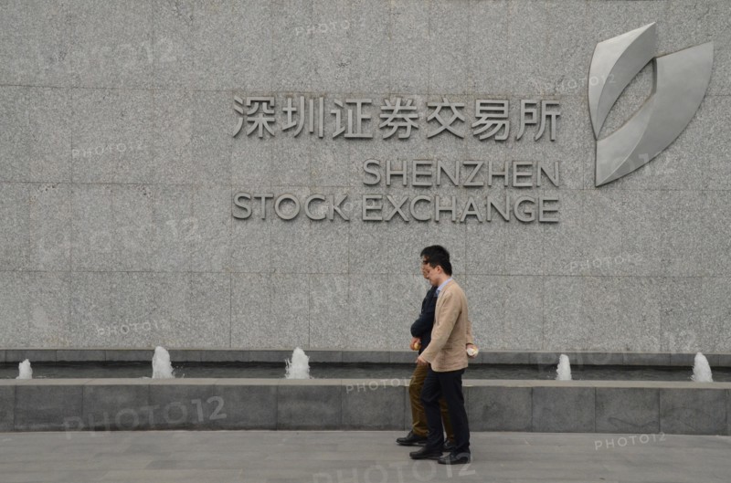 Two men walking by Shenzhen Stock Exchange, China.