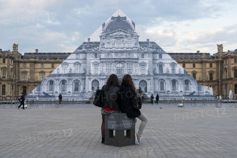 Louvre museum pyramid covered with thousands of paper sheets to make it disappear with an optical illusion.
