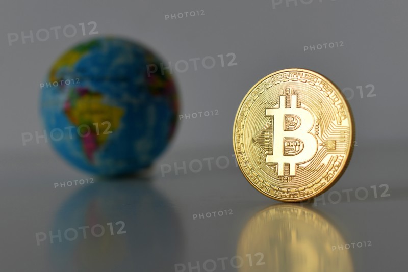Bitcoin concept. World economy concept. New world currency. Golden coin bitcoin and globe.