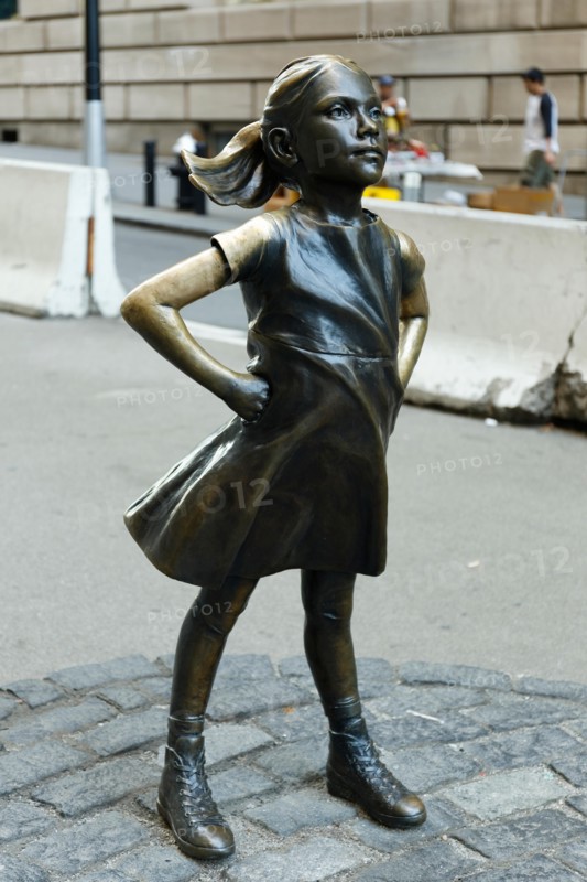 Girl in front of Charging bull sculpture at New York, USA,