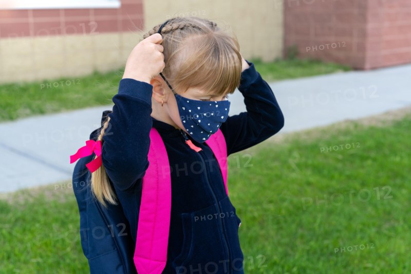 Young student caucasian girl wearing protective cotton mask for school. Return back to school, reopening, new life.