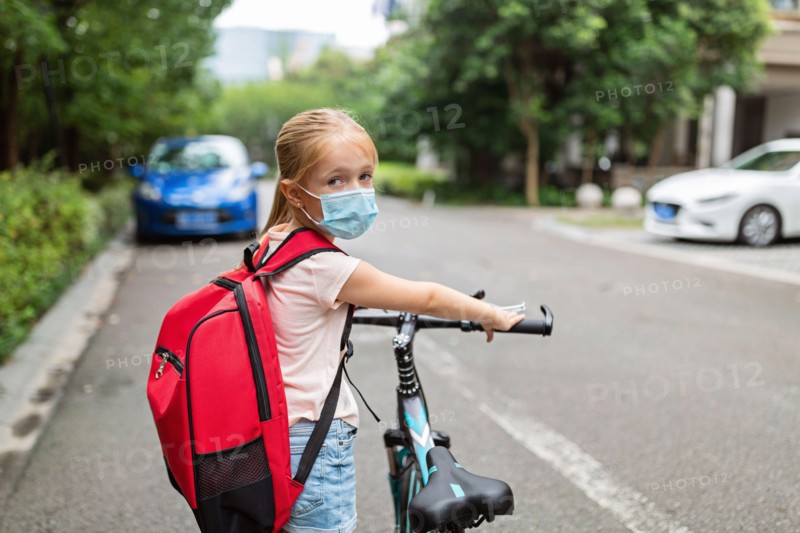 School child wearing face mask during coronavirus pandemic outbreak. Blonde girl going back to school after covid-19 quarantine and lockdown. Kid in
