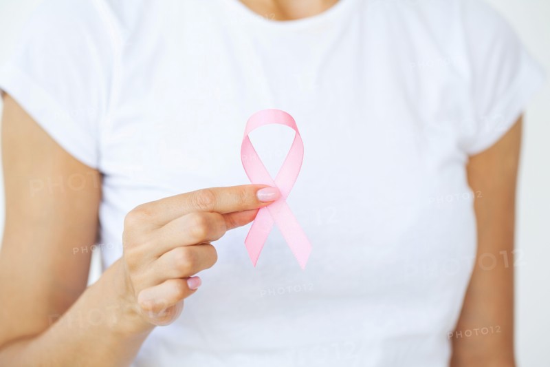 Woman using pink ribbon to support breast cancer cause or AIDS