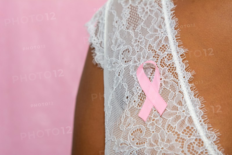 young african american woman with pink ribbon  isolated on pink , breast cancer concept