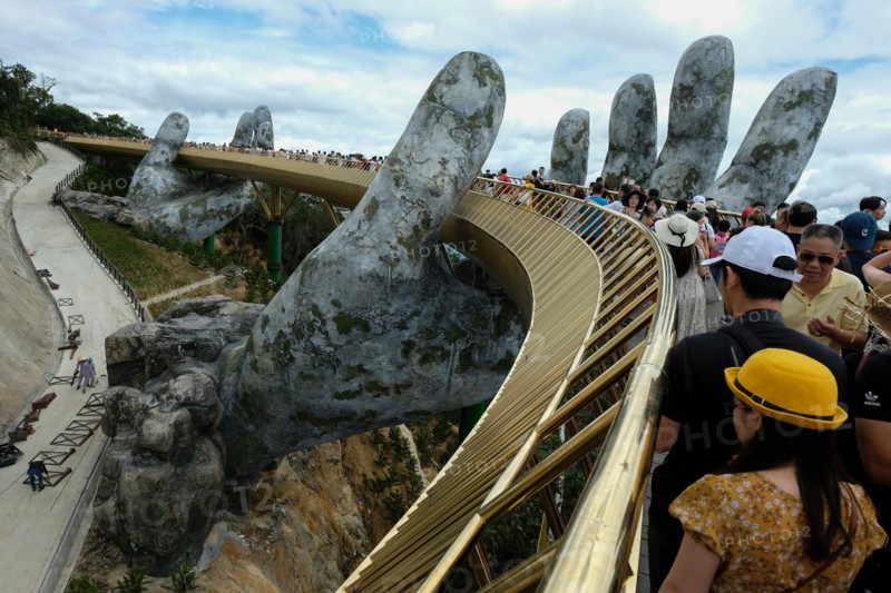 Da Nang, Vietnam - August 18, 2018: Tourists in the Golden Bridge. The Golden Bridge is a 150 m long pedestrian bridge in the Ba Na Hills in Da Nang.