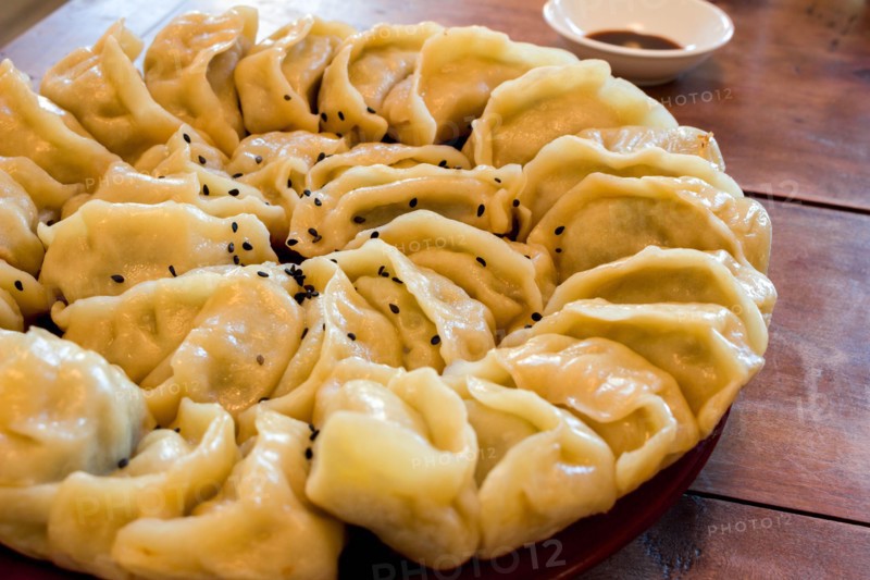 Hand-made Chinese dumplings Jiaozi with black sesame seeds beautifully arranged in a circle for Chinese New Year