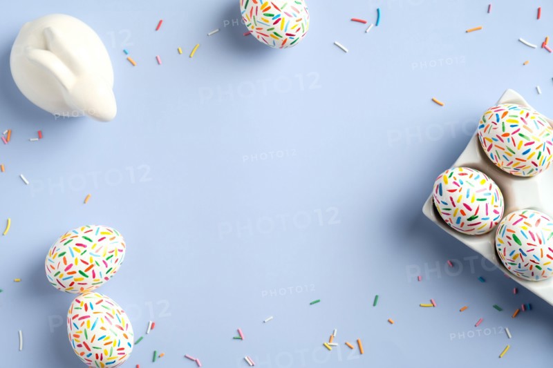 Cute Easter eggs and bunny on pastel blue background. Easter banner mockup. Flat lay, top view, copy space.