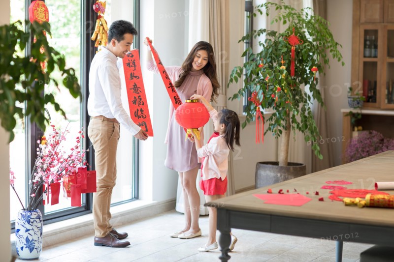 Happy family decorating their house for Chinese New Year