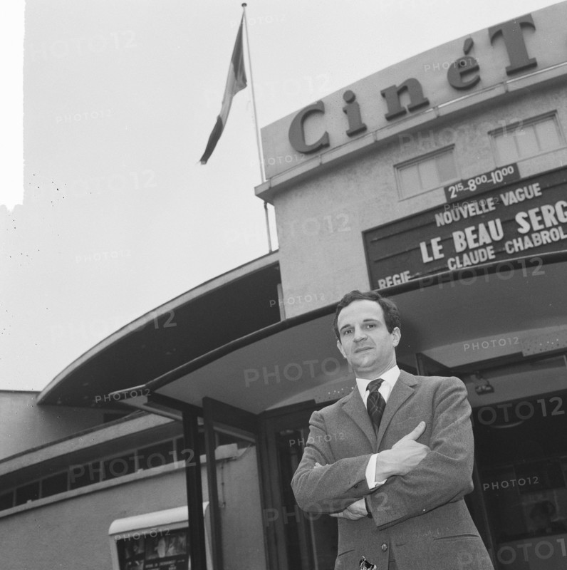 French director Francois Truffaut for cinema Cinétol, where his film plays [Le Peau Douce?] during Nouvelle Vague festival. [on billboard film by Claude Chabrol Le Beau Serge] Date: March 15, 1965 Location: Amsterdam, Noord-Holland Keywords: cinemas, films, portraits, directors Personal name: Cinetol, Truffaut, François