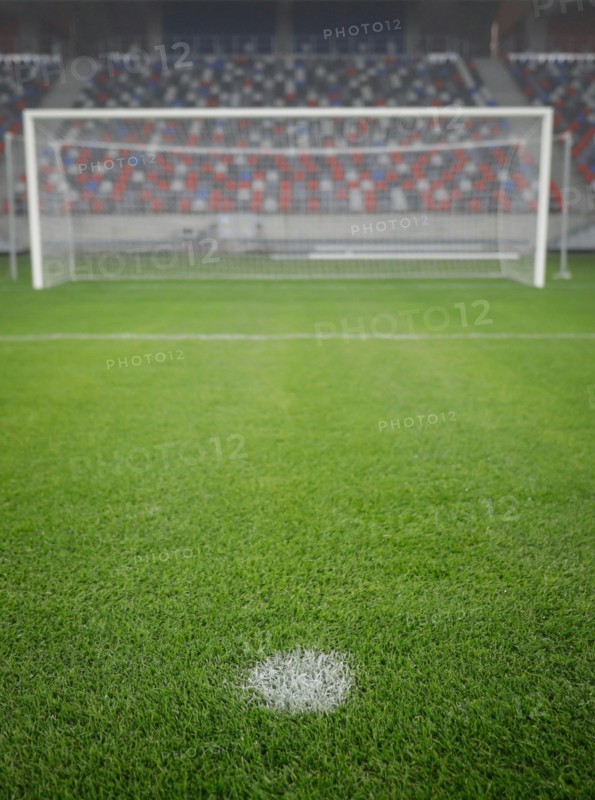 Shallow depth of field (selective focus) image with the penalty kick point on an empty soccer stadium.