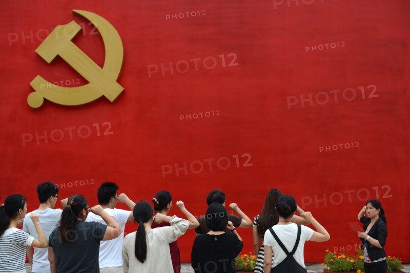 Chinese communists party members take an oath in front of the party flag sign at a  Party Memory Mesume as part of celebrations for the July 1 Chinese Communist Party's 94th anniversary in JiaXing, Zhejiang province, East China on 27th June 2015.