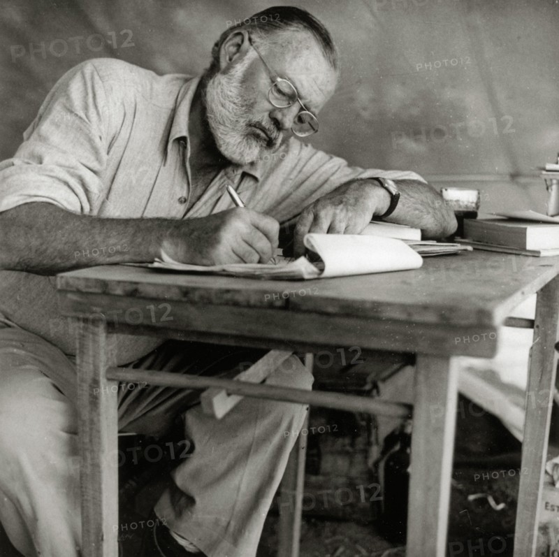 Ernest Hemingway Writing at Campsite in Kenya, circa 1953  File Reference # 1003_427THA