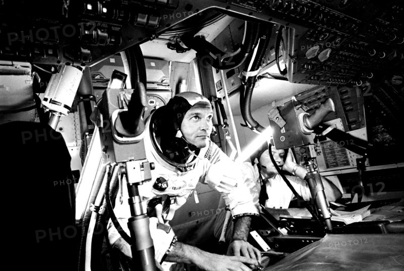 Photograph of the pilot Michael Collins at Apollo 11 Command Module, practicing docking hatch removal from CM simulator at NASA Johnson Space Center, Houston, Texas, June 28, 1969. Image courtesy National Aeronautics and Space Administration (NASA). ()