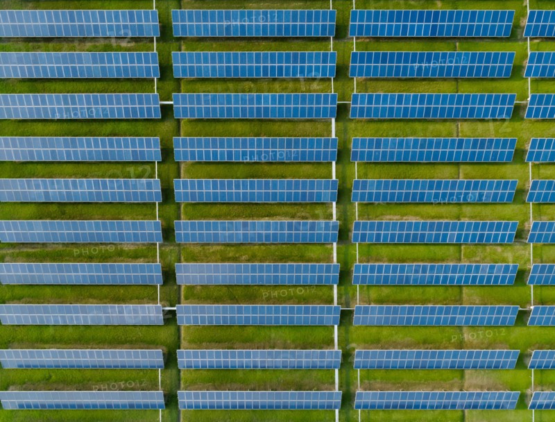 Aerial view of Solar Panels Farm with sunlight. Drone flight over solar panels field, renewable green alternative energy concept.