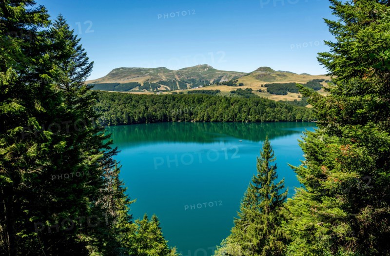 View on Volcanic lake of Pavin located in the Regional Natural Park of Auvergne Volcanoes, Sancy massif in the background, Auvergne, France, Europe